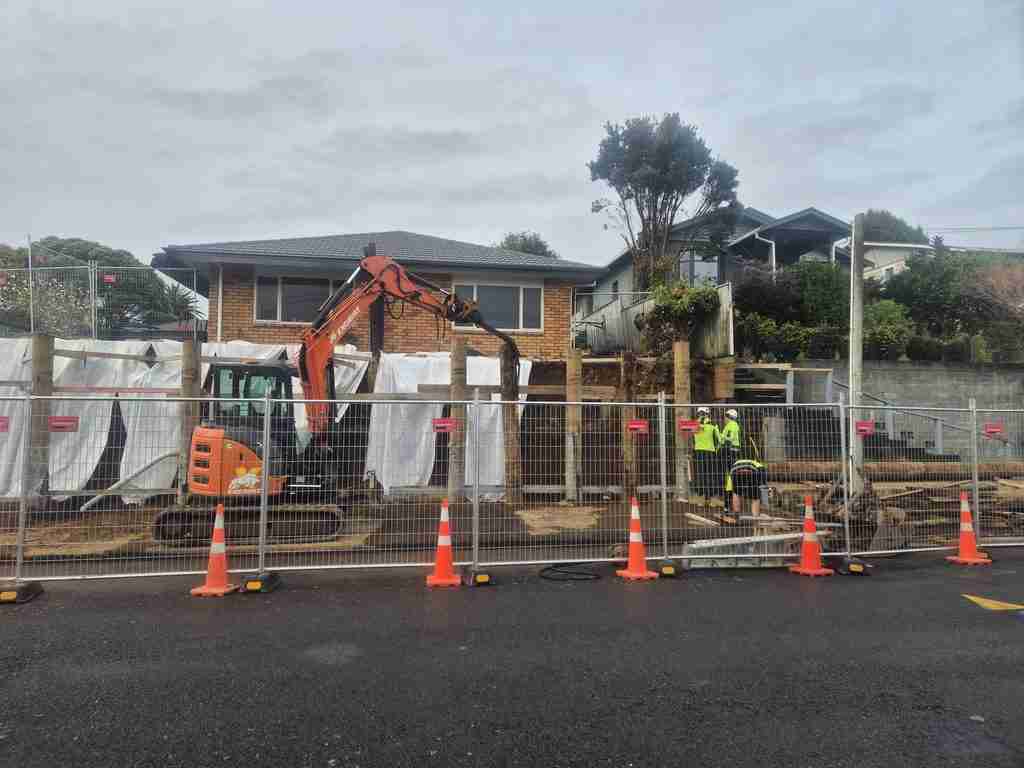 Excavat excavator building a new retaining wall below a house in New Plymouth